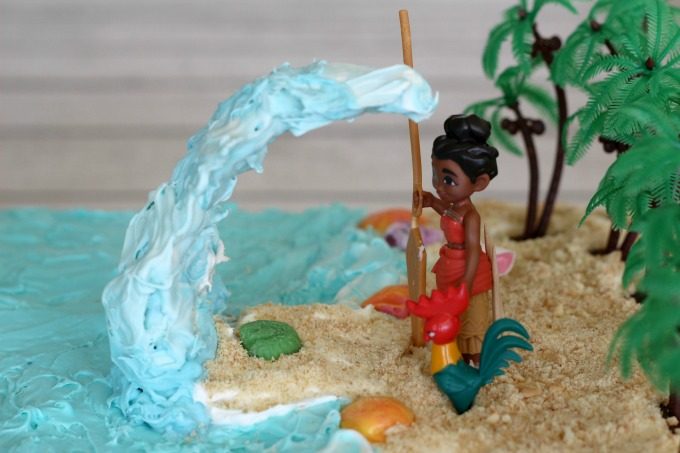 Add the wave and figurines to your Moana birthday cake