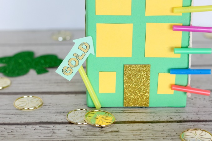 Glue the gold sign to the building so the leprechaun knows where to go.