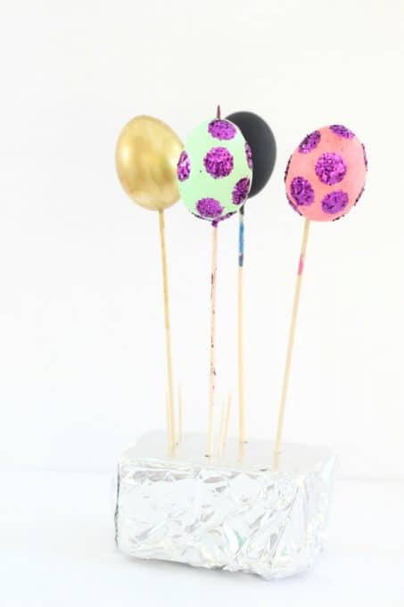 To dry your Easter eggs with nail polish, stick the end of the skewer in floral foam
