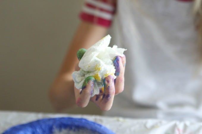 Painted hand holding paper towel