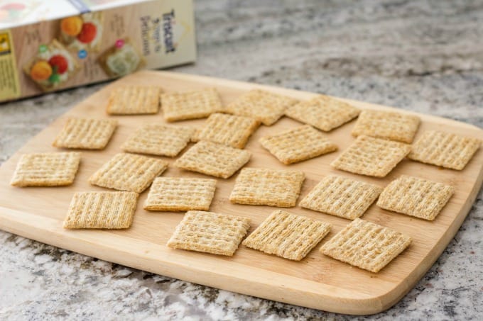 Spread Triscuit crackers on a tray or cutting board