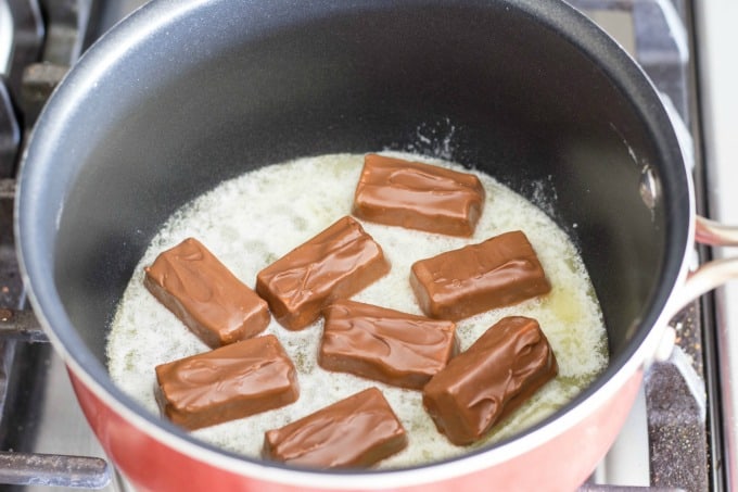 To make the party mix recipe, you'll have to first melt Snickers and butter together in a saucepan.