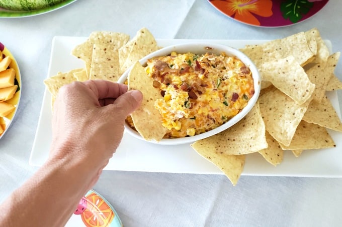 Dipping a chip in hot corn dip