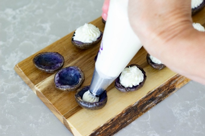 Filling purple potatoes with goat cheese