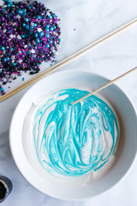 Stirring blue food coloring into ice cream mixture