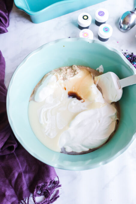 Mixing condensed milk, whipping cream and vanilla in a blue bowl