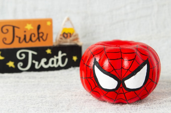 Spiderman pumpkin with a trick or treat sign