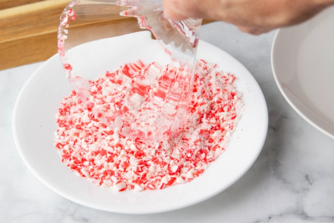 Dipping a martini glass into crushed peppermint pieces