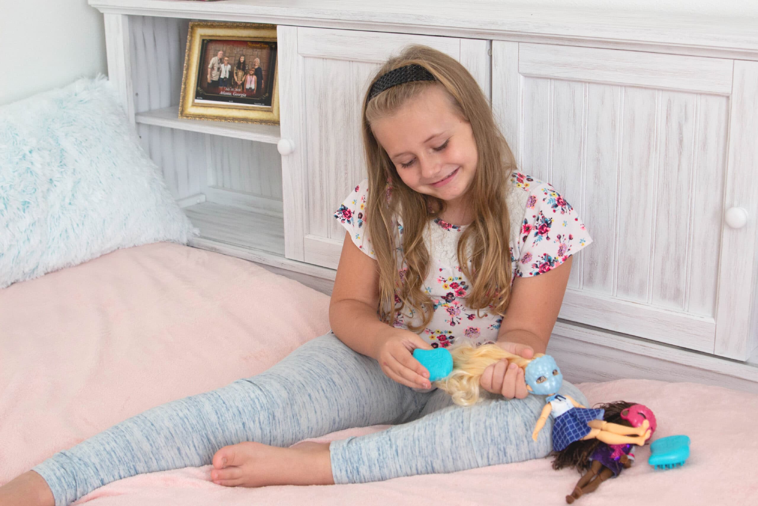 Little girl brushing dolls hair