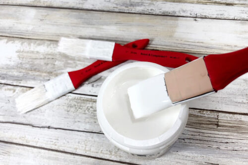 Dipping paintbrush in white paint for Santa ornament