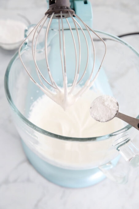 Adding powdered sugar to whipped cream