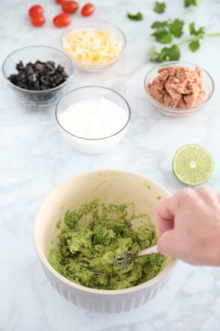 Making guacamole for seven layer dip cups