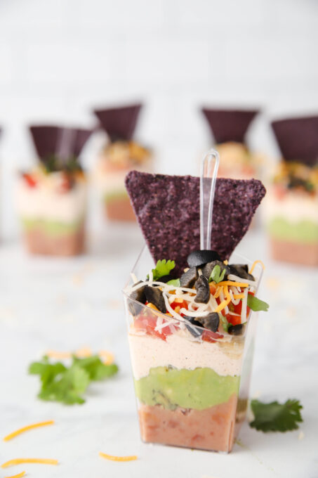 Seven Layer Dip Cups with tortilla chips.