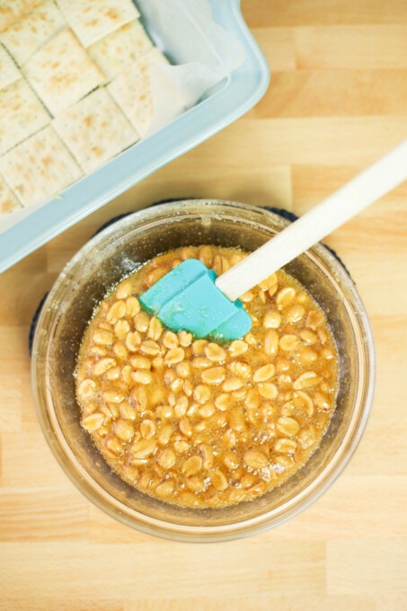 Mixing peanuts with syrup and sugar