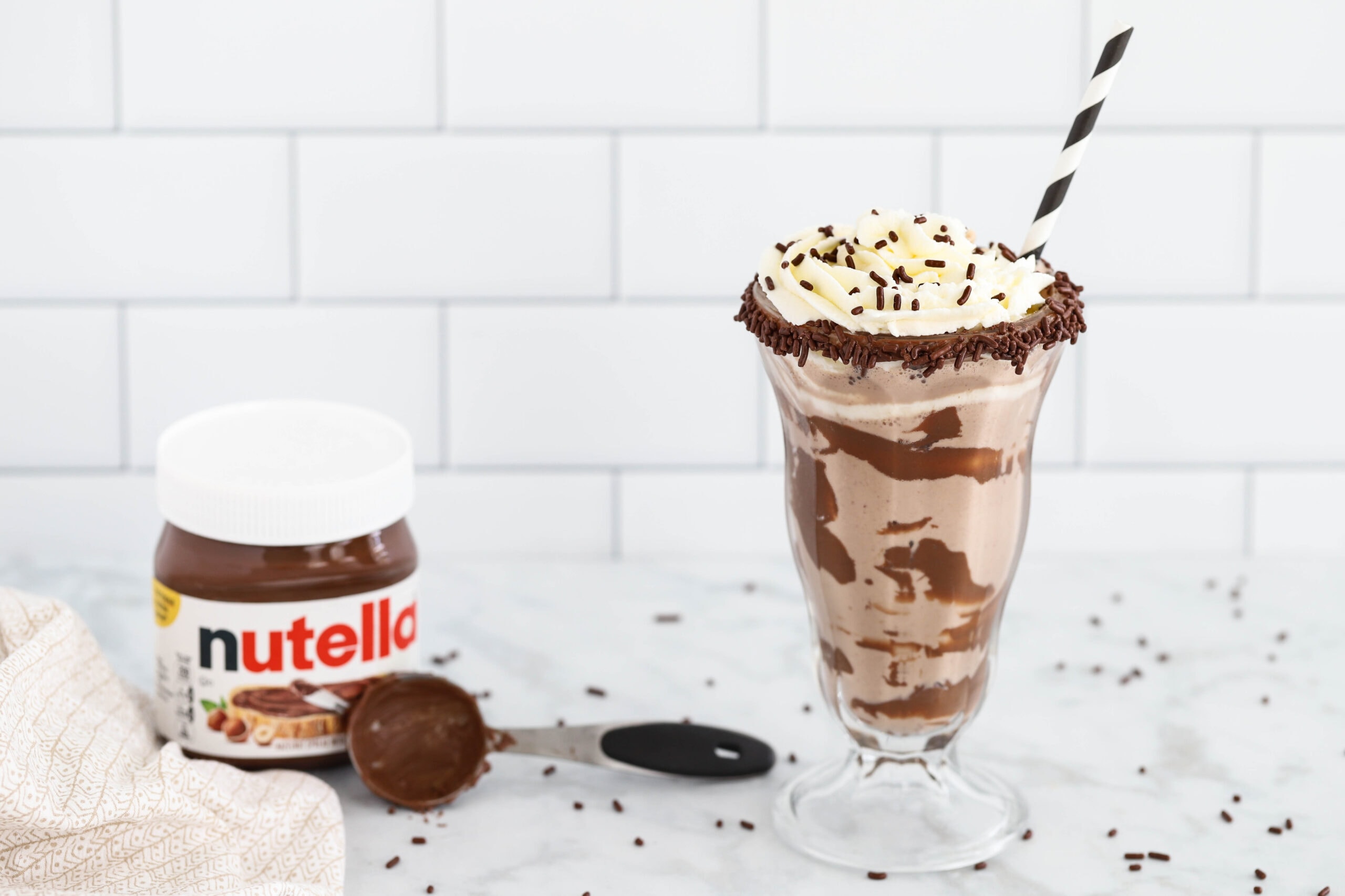 Nutella milkshake with Nutella and measuring spoon