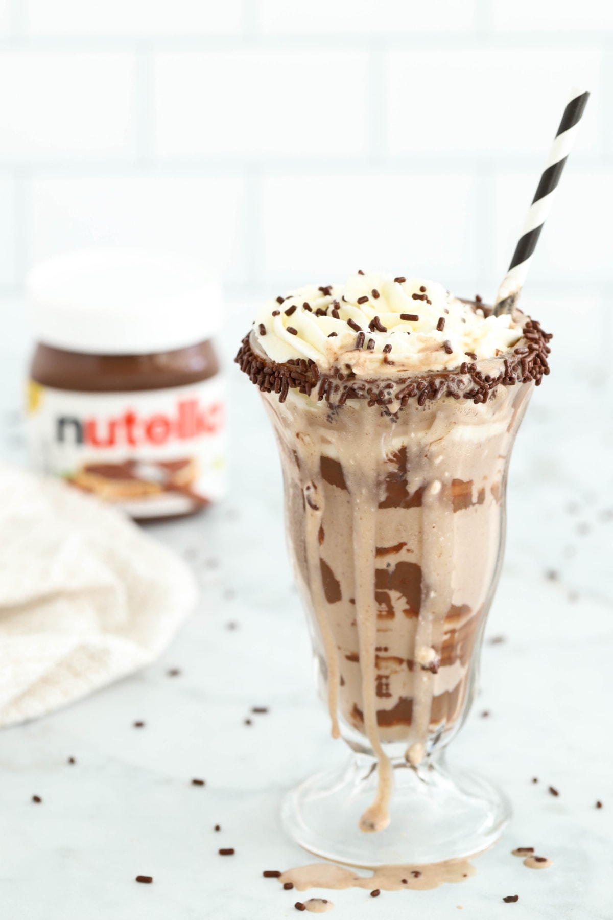 Easy Nutella milkshake with Nutella jar in background