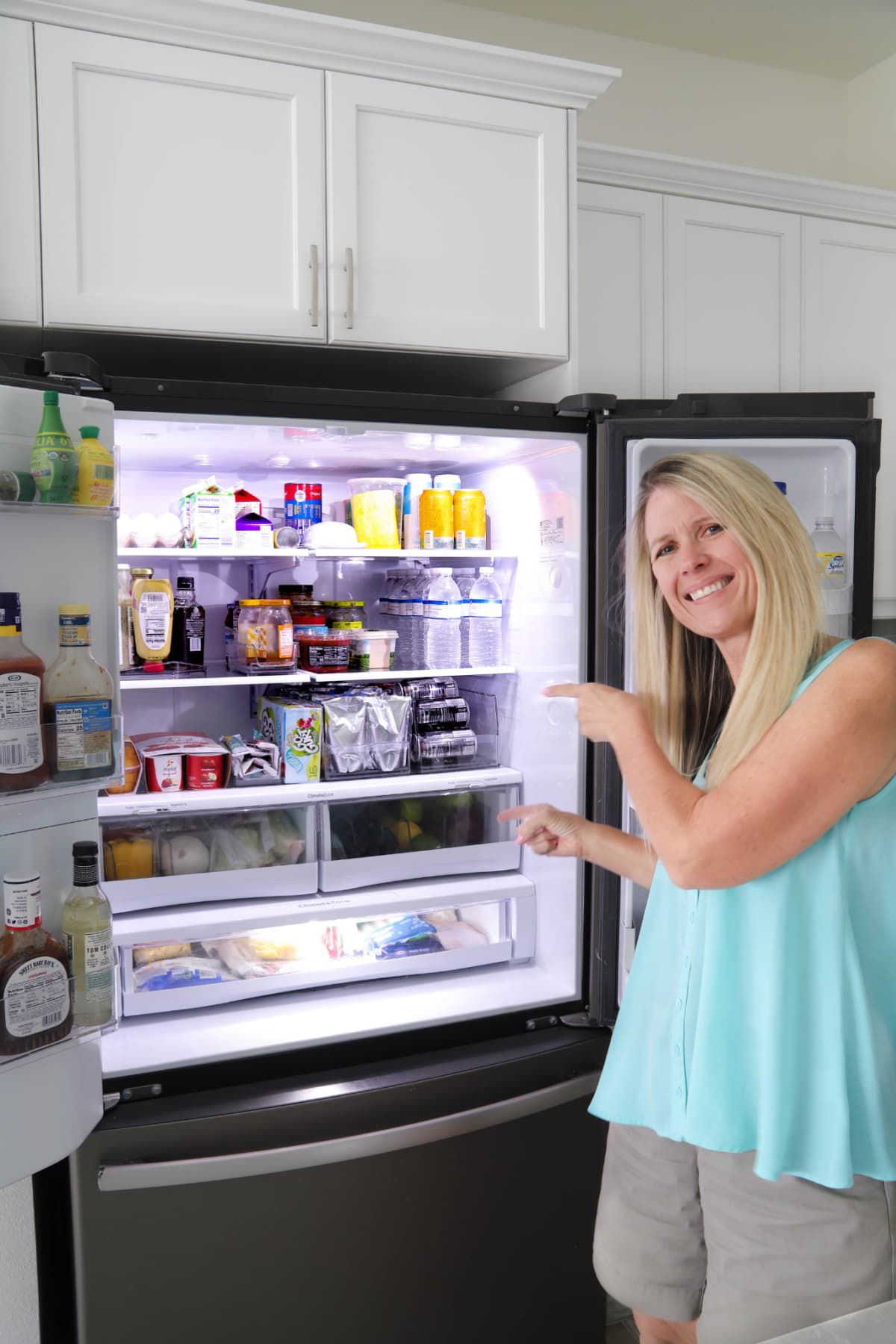 Woman pointing to the inside of a refrigerator