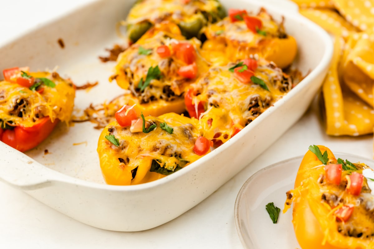 Taco stuffed bell peppers on plate and in casserole dish