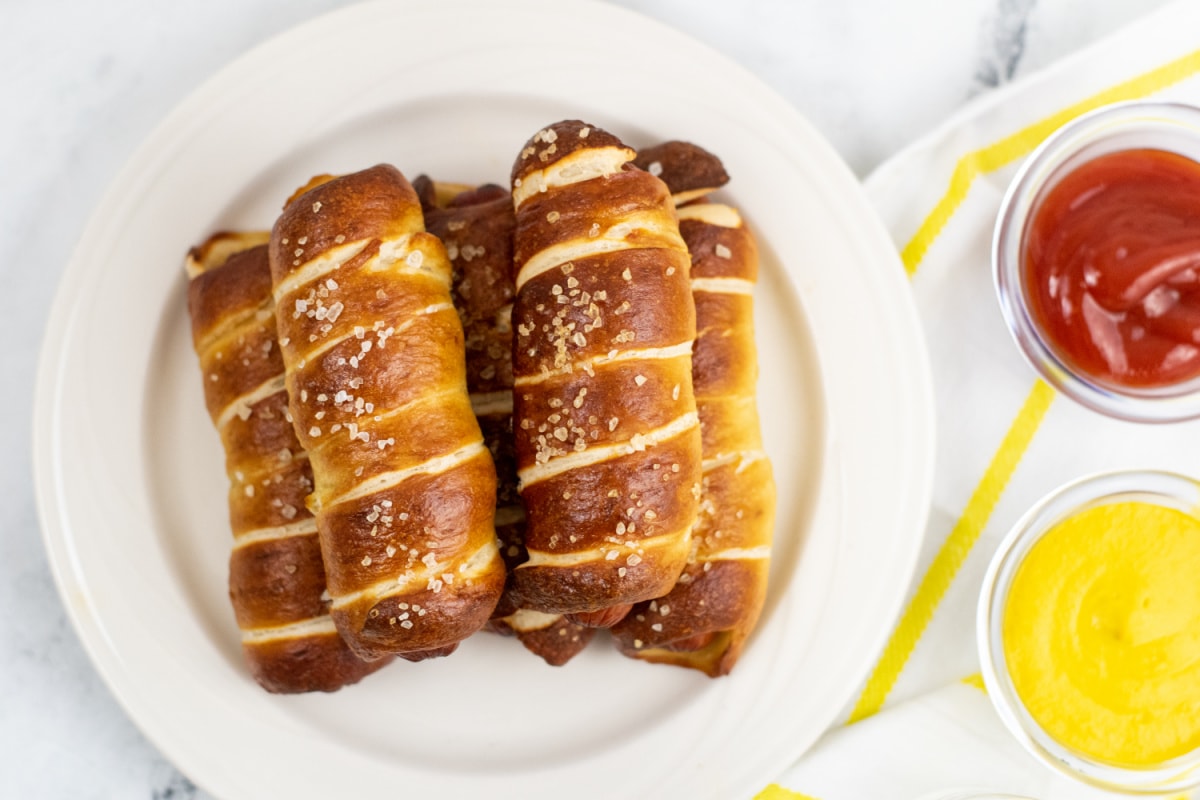 Pretzel dogs with bowls of ketchup and mustard