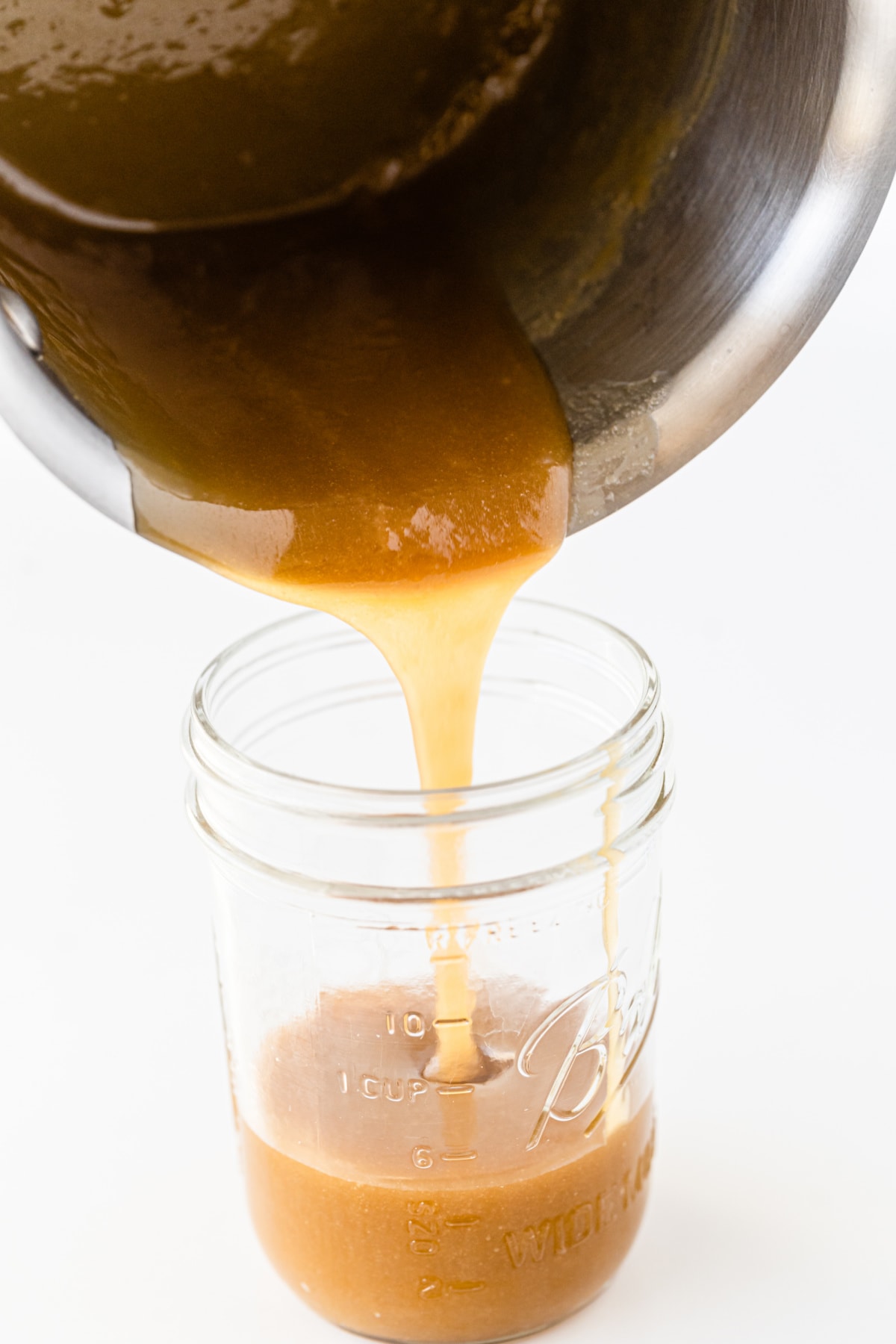 Pouring butterscotch sauce ingredients into jar