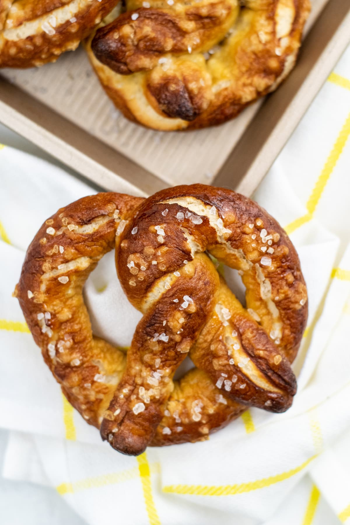 Soft pretzel with tray of pretzels