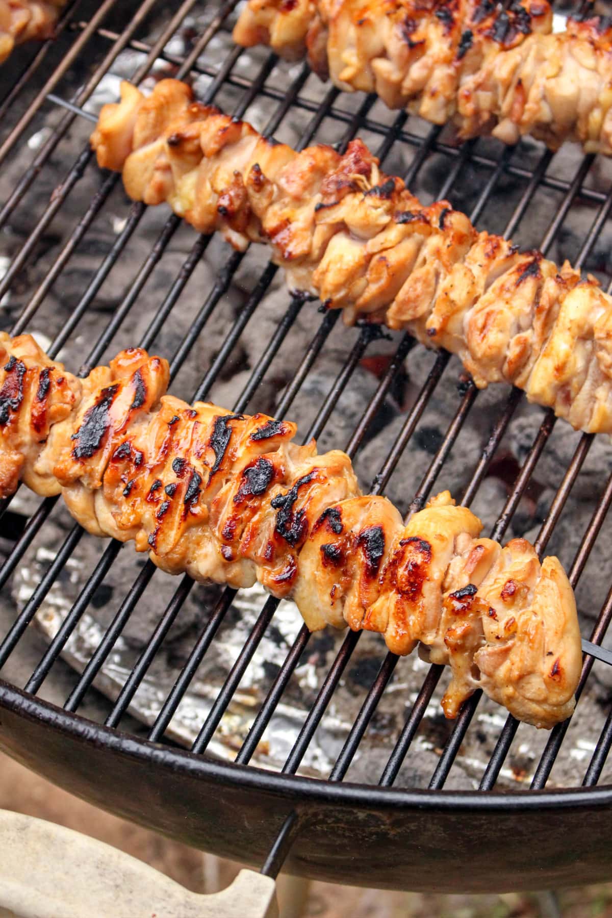 Chicken kabobs cooking over charcoal