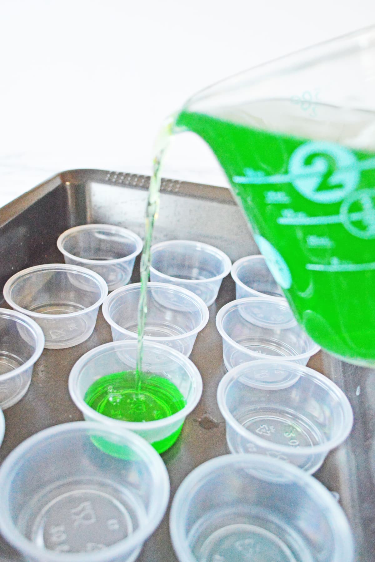 Pouring jello shot mix into plastic cups