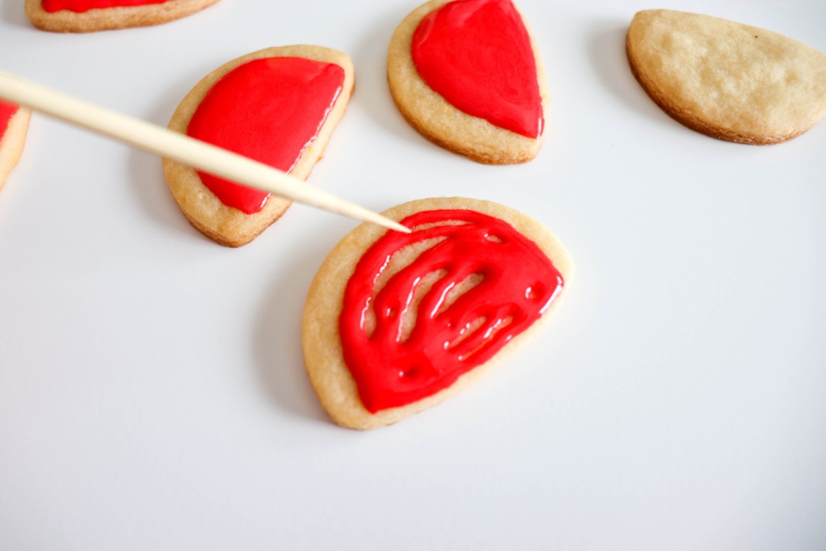 Filling in the red icing on cookies
