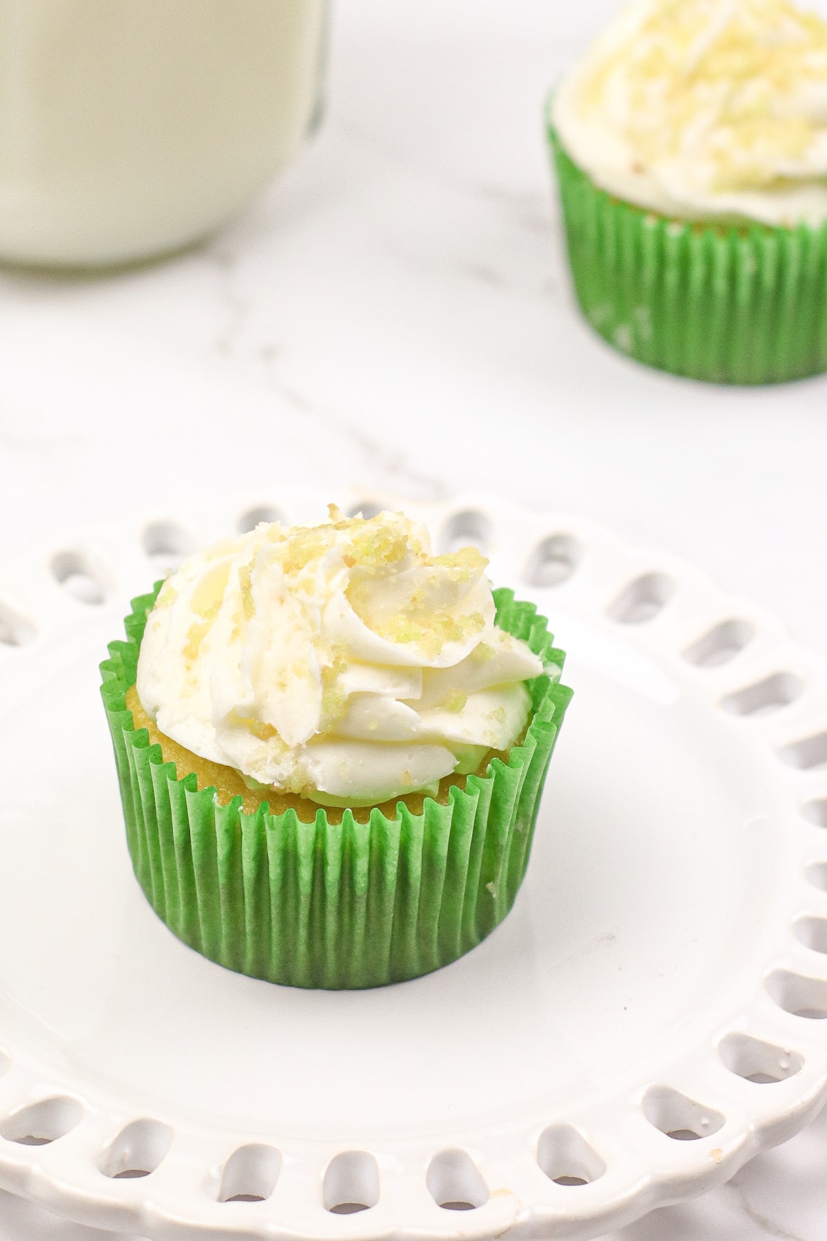 Coconut lime cupcake on white plate