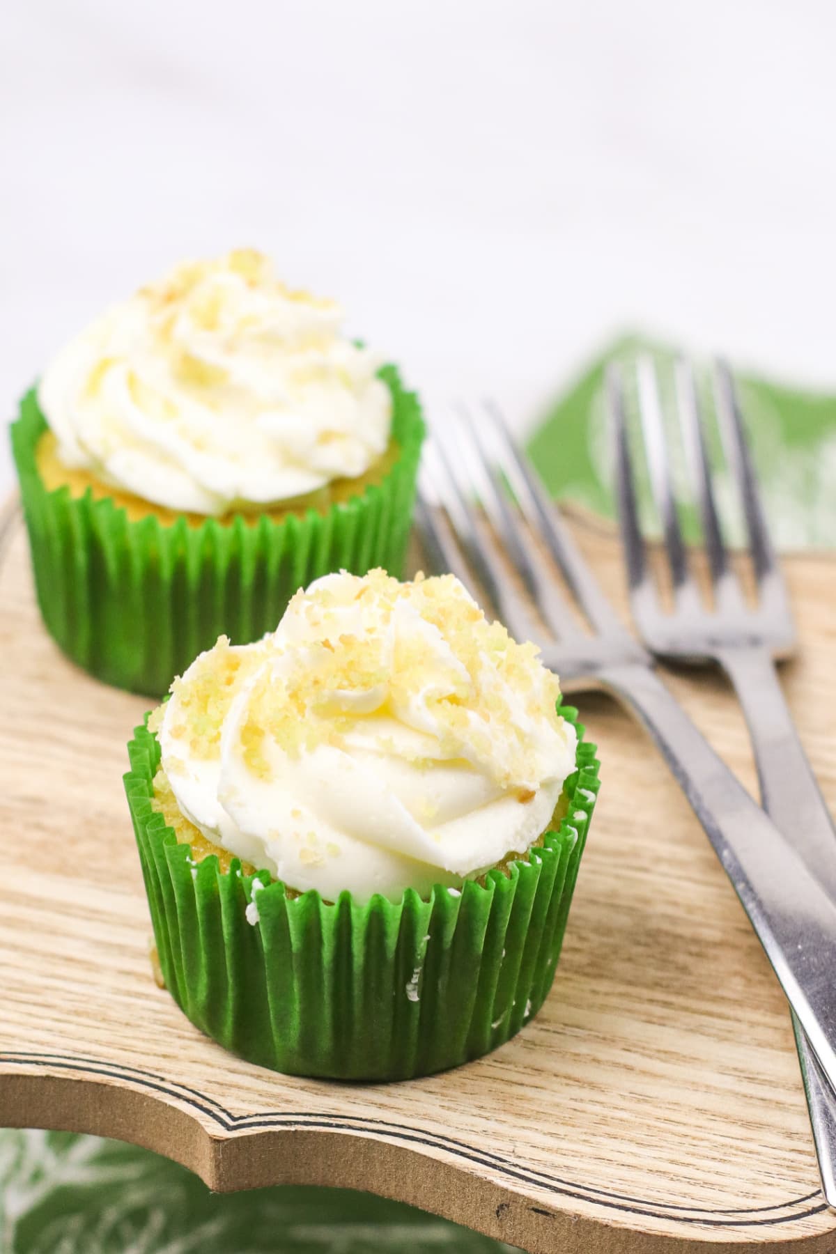Two coconut lime cupcakes with forks