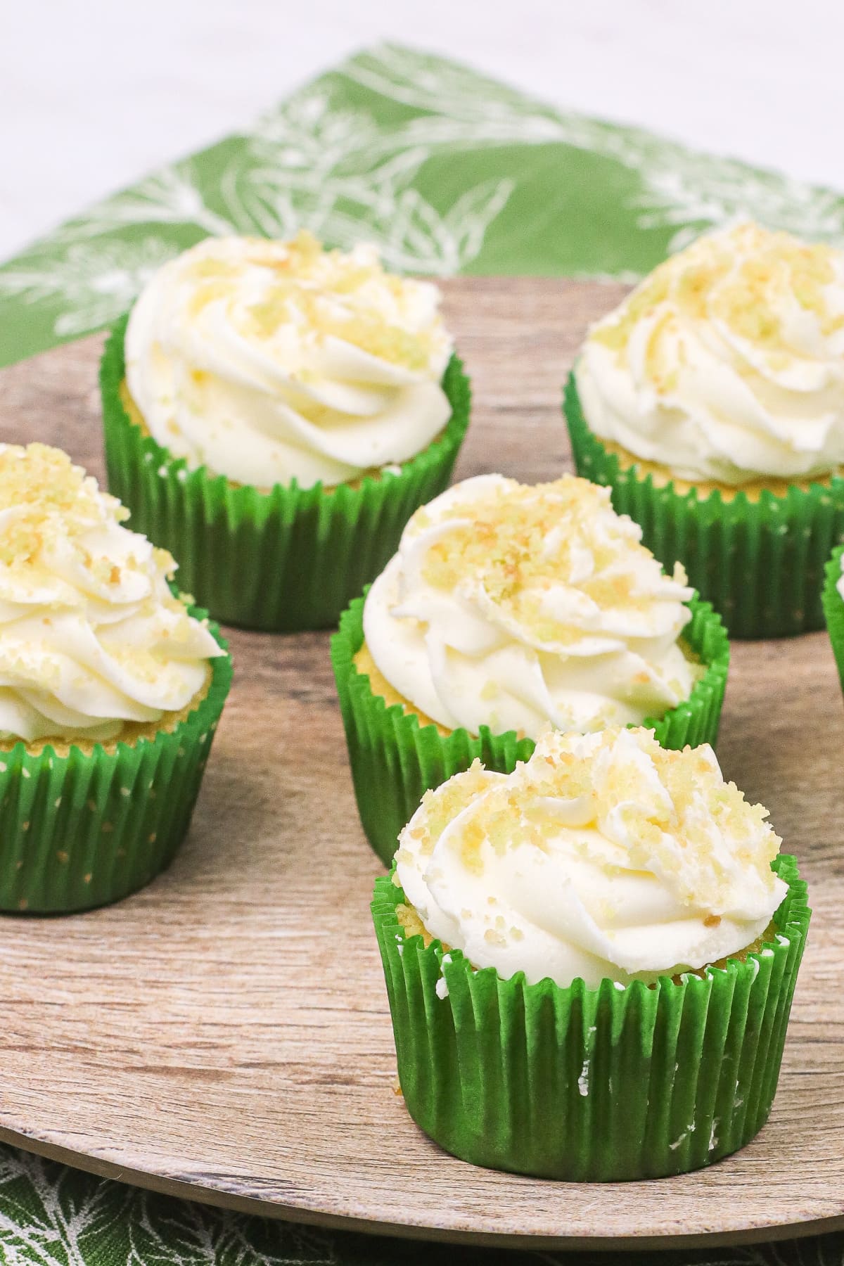 Coconut lime cupcakes on wood circle