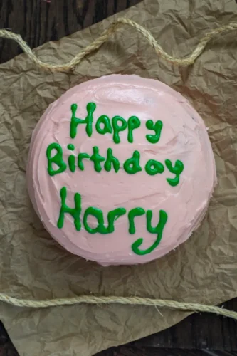 Pink birthday cake with green writing