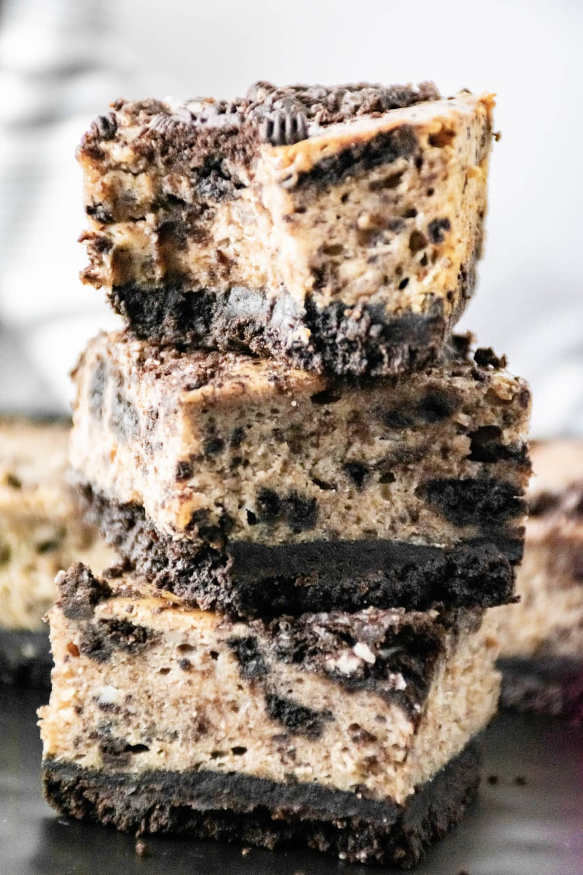 Oreo cheesecake bars stacked with bite out of one