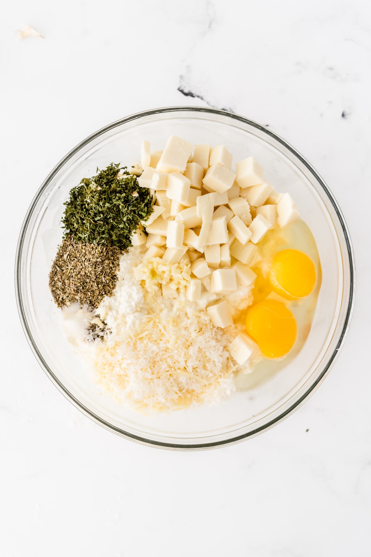 Eggs, cheeses and spices in mixing bowl