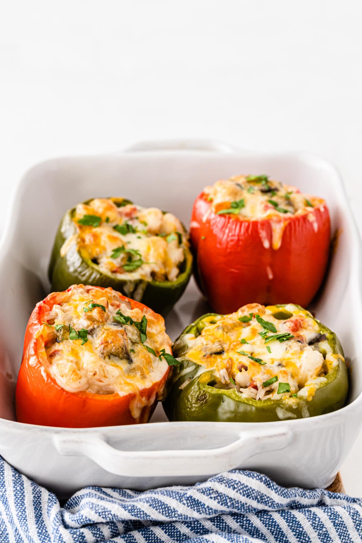 Stuffed peppers with shrimp and rice in white baking dish