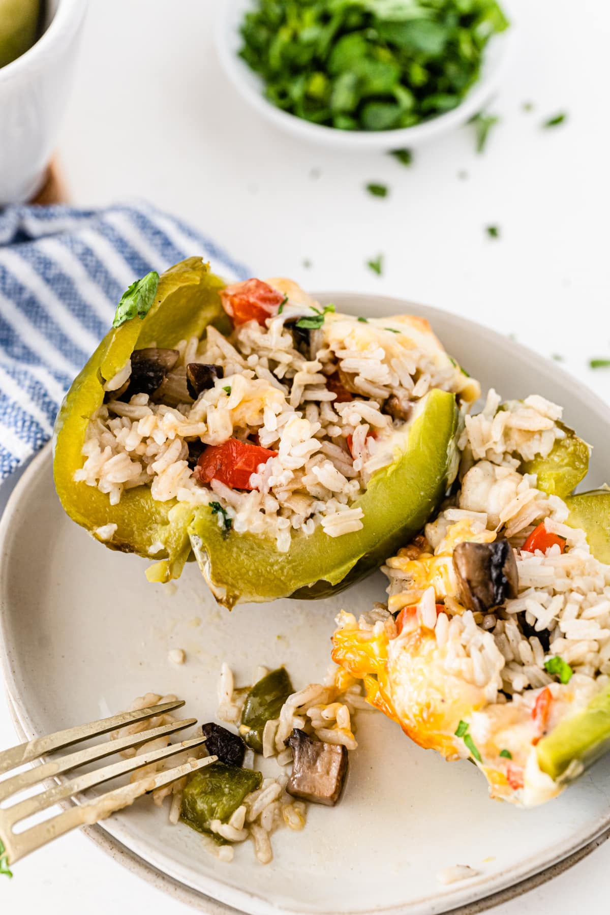 Stuffed green pepper with rice cut open on plate
