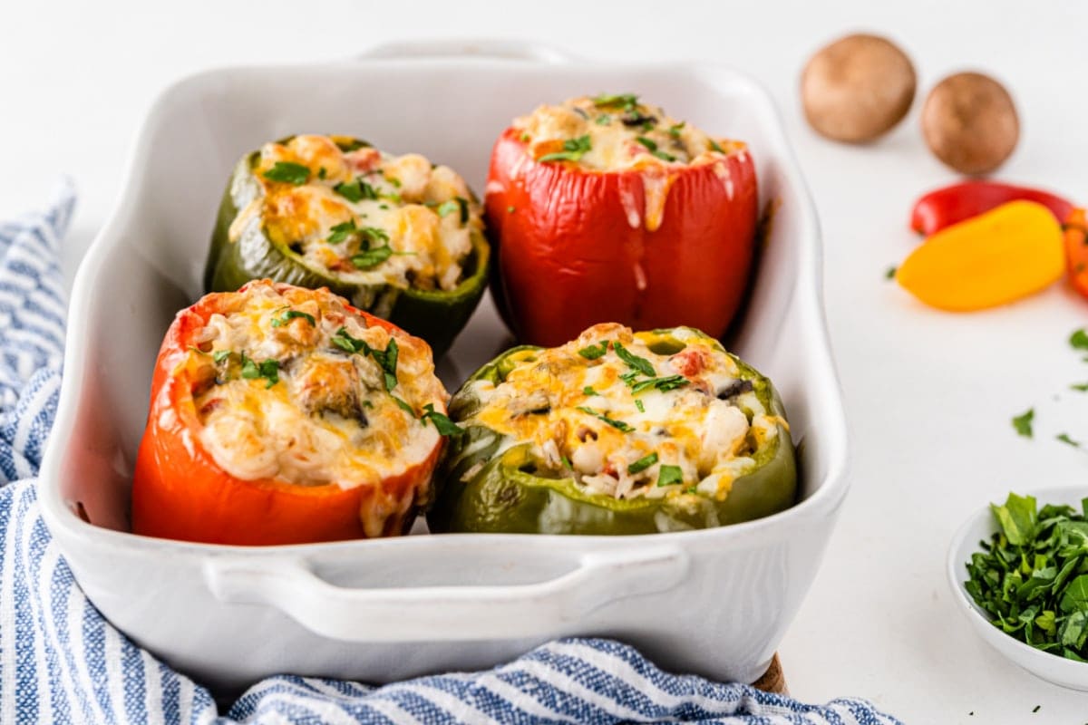 Red and green stuffed peppers with shrimp in white baking dish