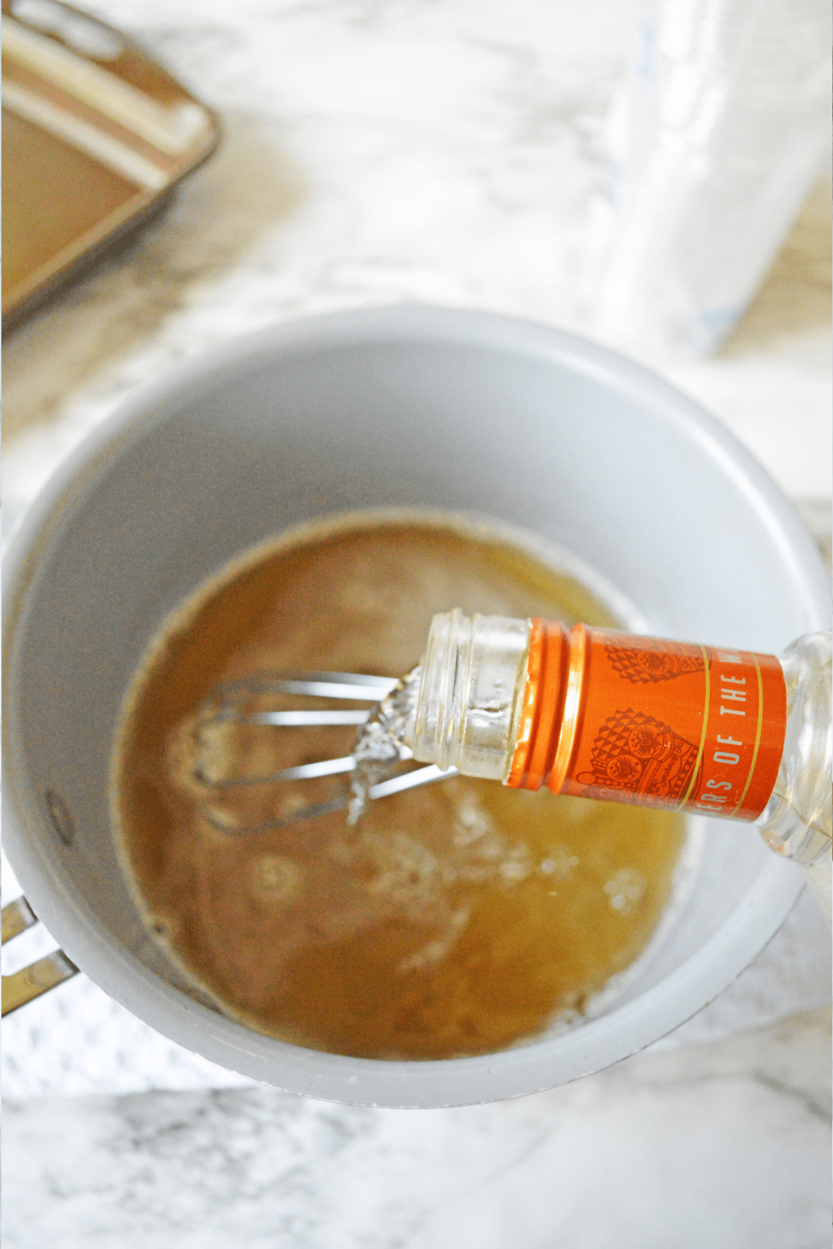 Pouring caramel vodka into cream soda mixture