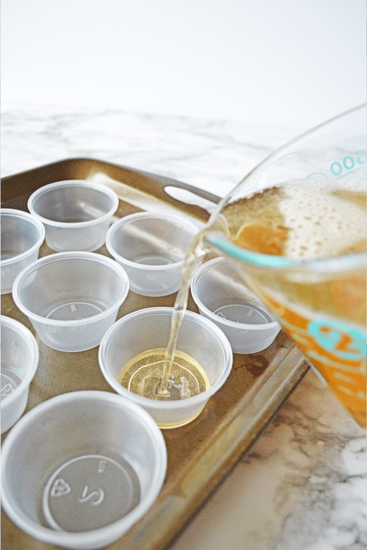 Pouring jello shots into plastic cups