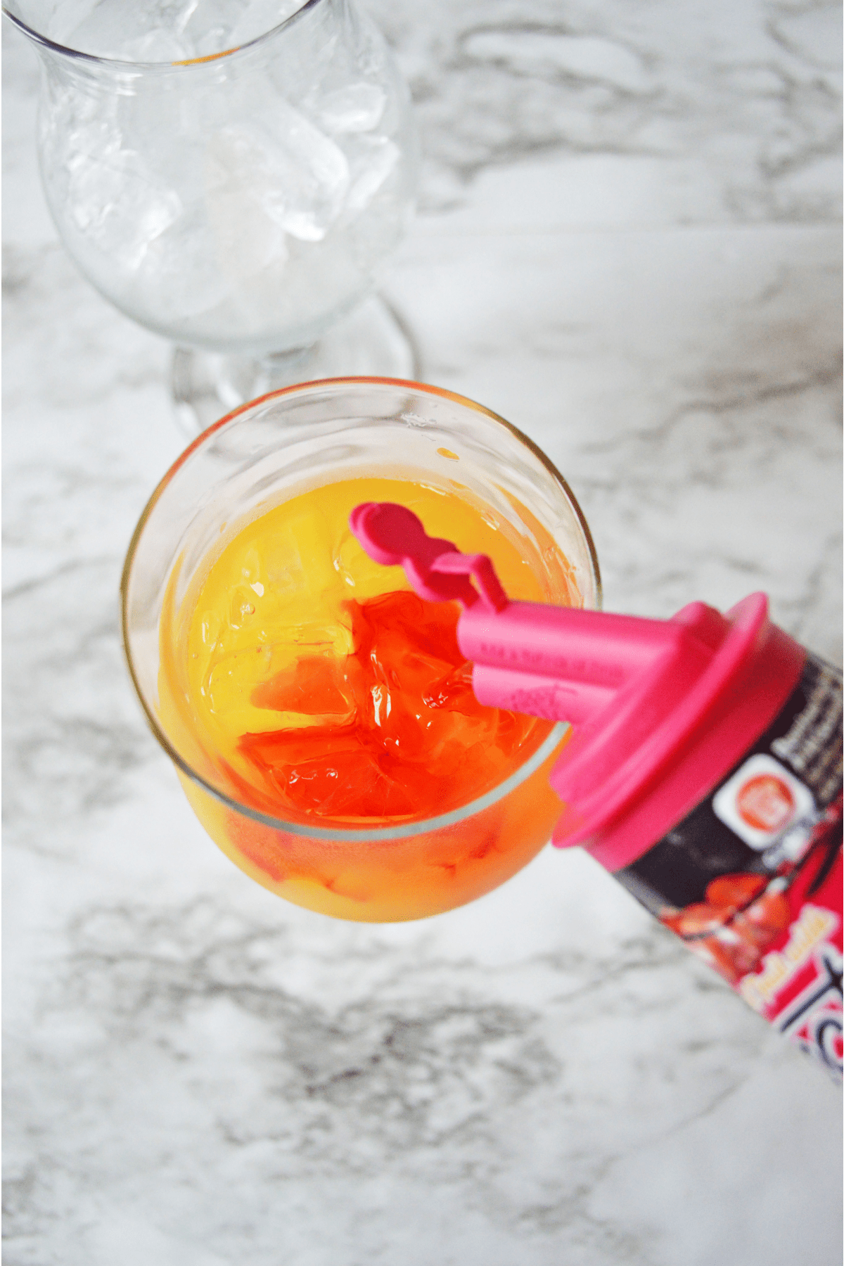 Topping off Caribbean Rum Punch with grenadine