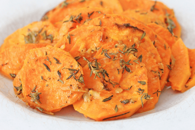 Roasted sweet potato slices in white dish up close