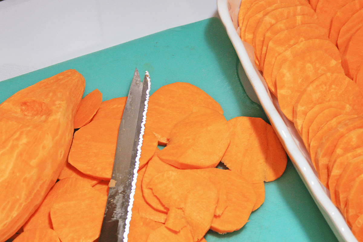 Sliced sweet potatoes on blue cutting board