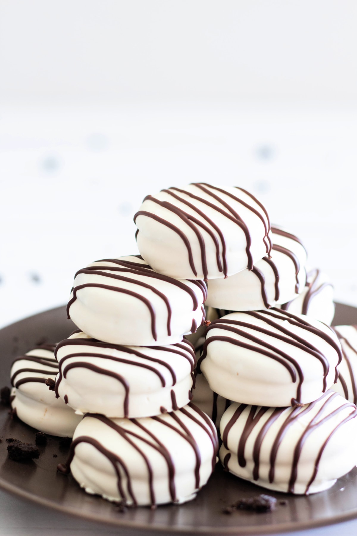 White chocolate covered Oreo cookies stacked on plate