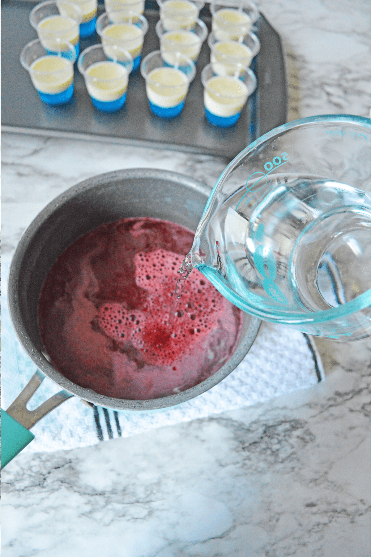 Pouring water into red jello mixture