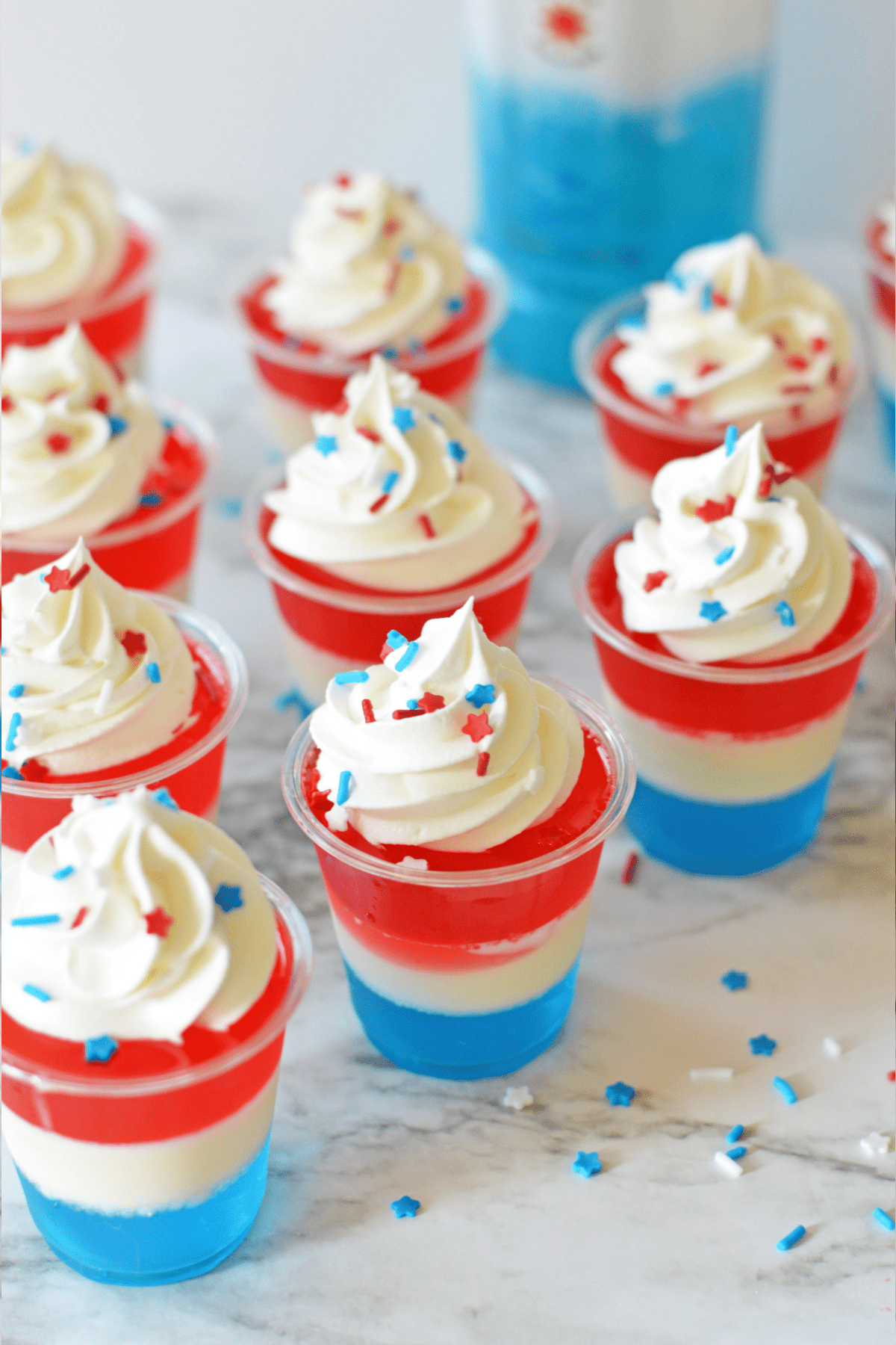 4th Of July Jello shots topped with whipped cream and sprinkles