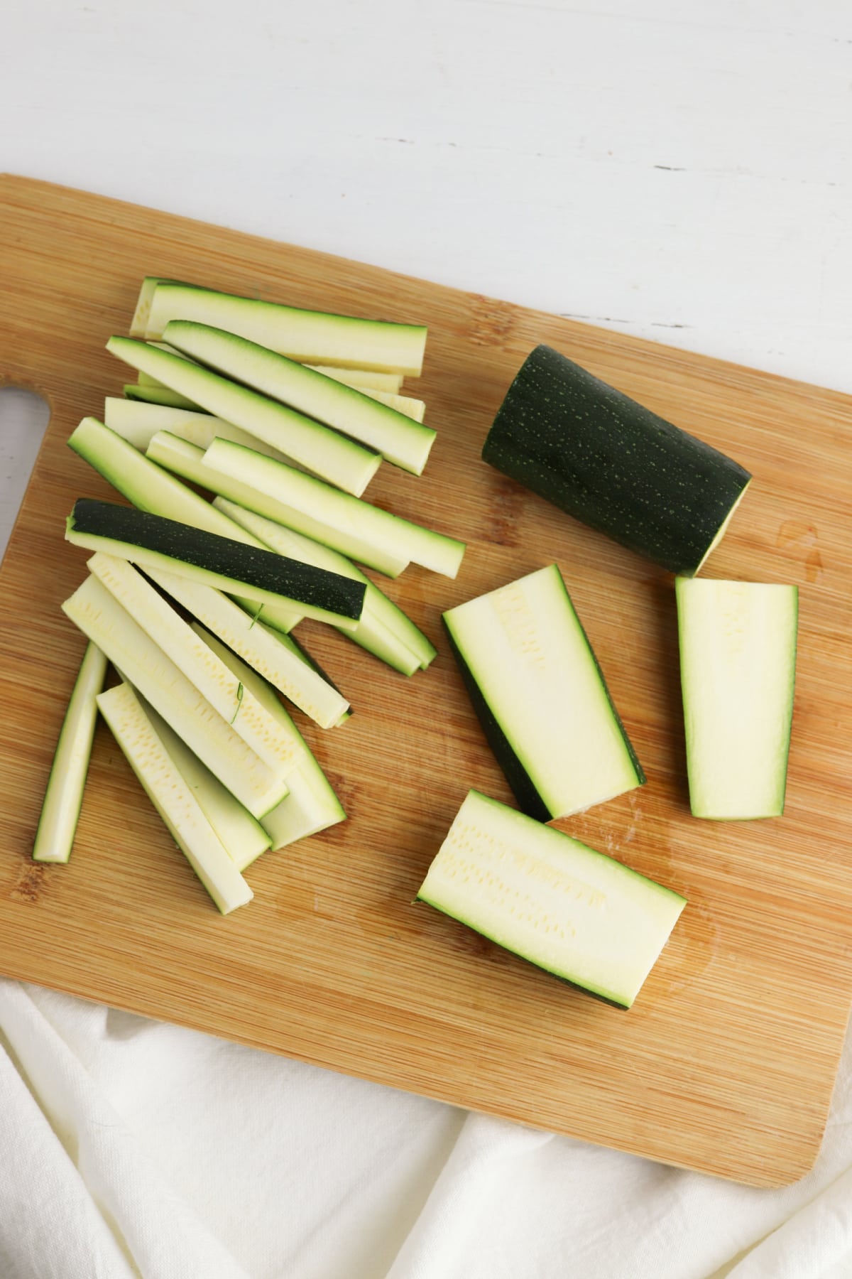 Zucchini pieces on wooden cutting board