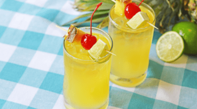 Pineapple Mai Tai cocktails with lime and pineapple in background
