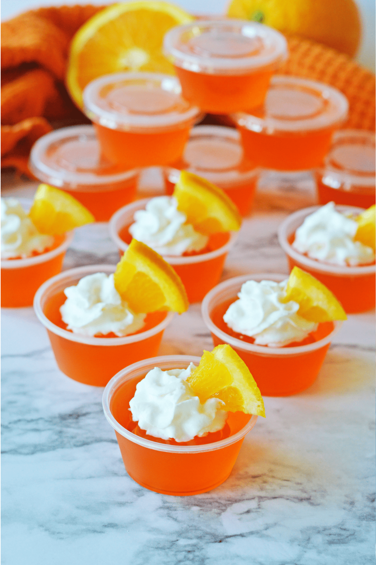 Orange creamsicle jello shots with whipped cream and orange slice