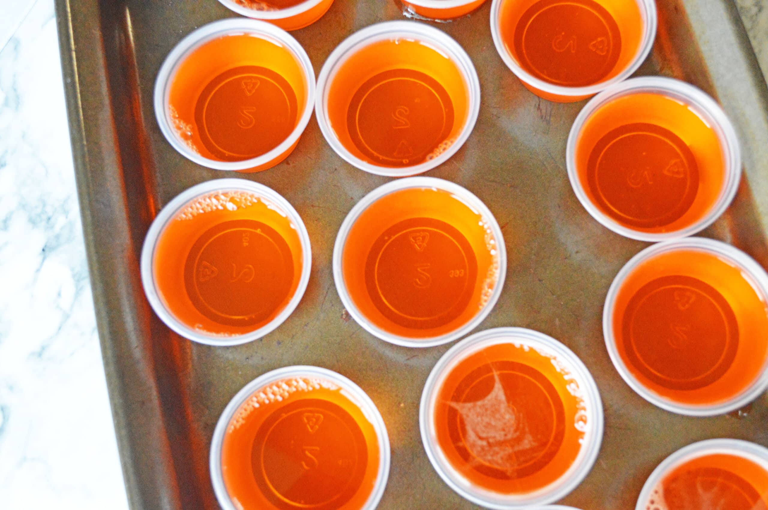 Orange jello shots on baking sheet