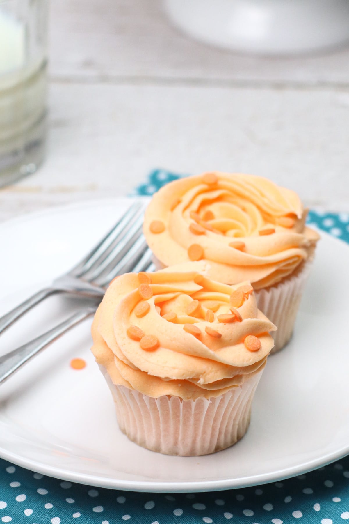 Two peach cupcakes on white plate